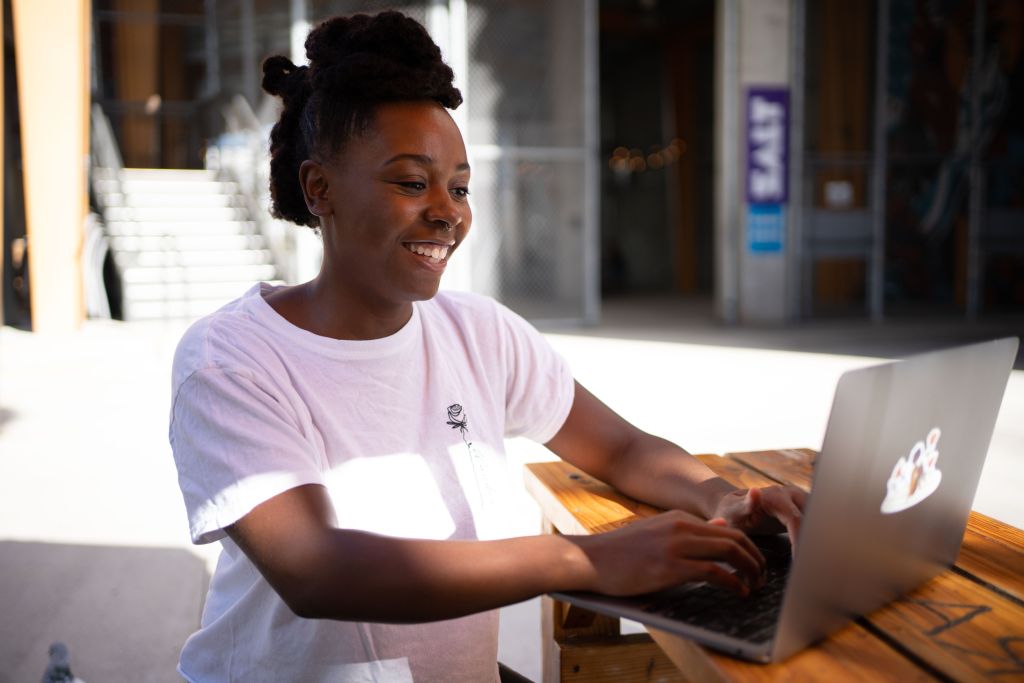 woman-sits-at-wooden-table-and-works-on-a-laptop